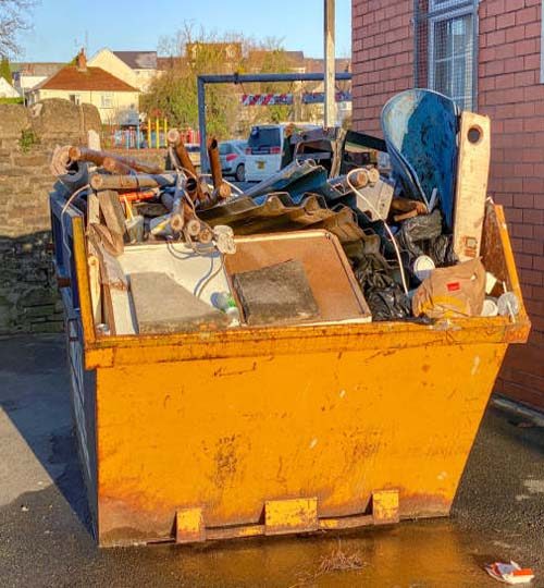 Pontypridd, Wales - January 2020: Large industrial skip filled with waste after the refurbishment of a building.